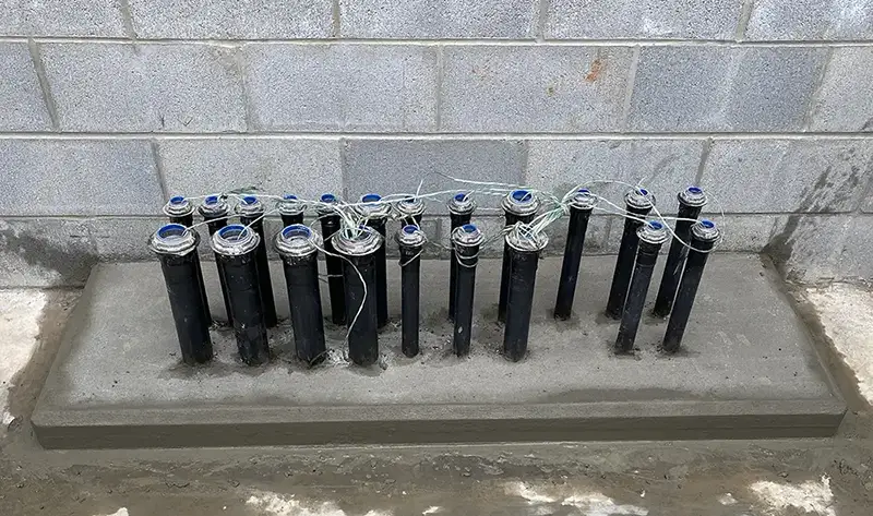 pipes with wires and a concrete block wall