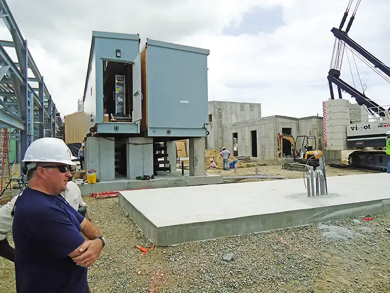 workers watching a crane on a construction site