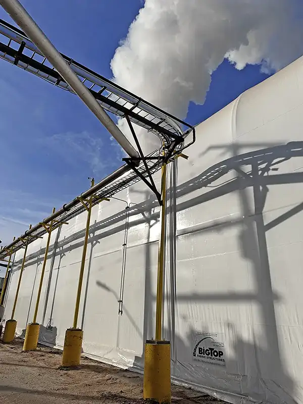 white concrete building with vapor coming out above it