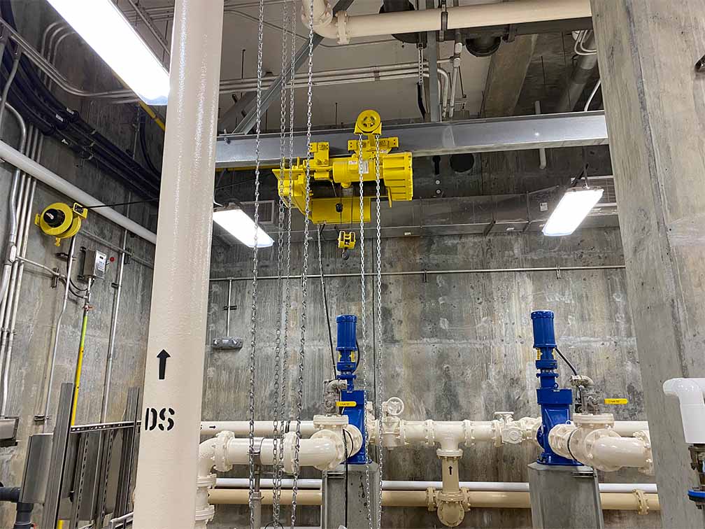 interior of large concrete building with electrical wiring and piping
